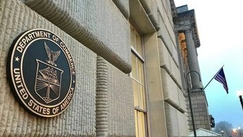 Department of Commerce bronze seal on stone building exterior with US flag
